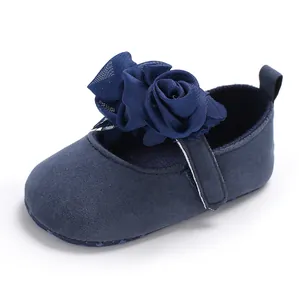 Nahaufnahme eines dunkelblauen Baby-Prinzessin-Schuhs mit großer eleganter Stoffblume.
