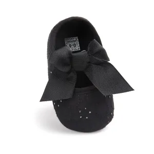 Detailed close-up showing black baby girl soft sole walking shoes with a large bow