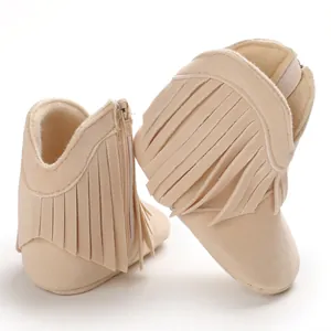 Macro detail of soft-sole baby boots featuring stylish fringe and side zipper closure