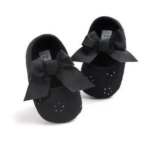 Detailed view of black baby princess shoes featuring large bows and embroidery details