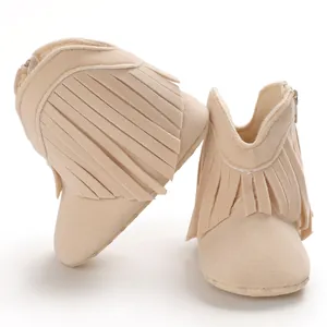 Close-up view of soft suede baby boots featuring stylish fringe and side zipper closure