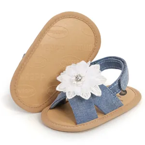 Gros plan de sandales en jean pour bébé avec semelle souple et fleur