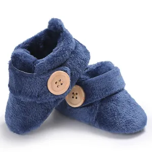 Detailed view of dark blue plush baby walking shoes with decorative wooden button