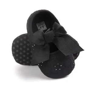 Close-up of black embroidered baby princess shoes with a large bow and soft anti-slip sole.