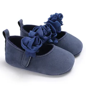 Detailansicht von dunkelblauen Baby-Prinzessinenschuhen mit Stoffblumen und Klettverschluss