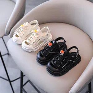 Close-up detail of children's sport sandals in black and white faux leather finish.