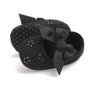 Detailed view of black baby princess shoes featuring large bow and floral embroidery