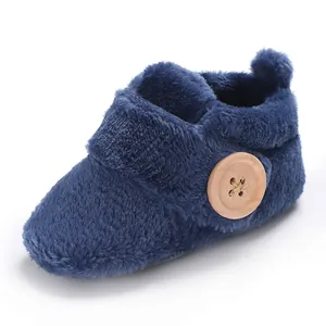 Detailed view of navy blue plush baby walking shoe with a decorative wooden button