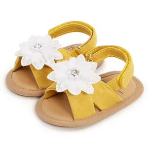 Vue détaillée de sandales jaunes pour bébé avec fleurs en dentelle blanche délicates