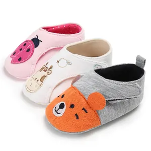 Vue détaillée de trois chaussures pour bébé aux motifs d'animaux avec semelles souples