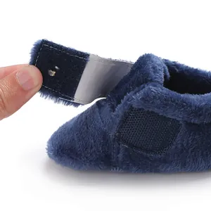 Close-up of navy blue plush baby walking shoe featuring a functional hook-and-loop strap detail.