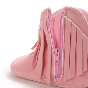 High-quality detail shot of side zipper and pink fringe decoration on baby boots