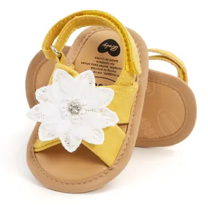 Vue détaillée de sandales jaunes pour bébé ornées d'une fleur en dentelle blanche.