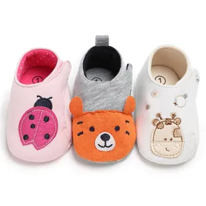 Vue détaillée de chaussures bébé souples avec motifs de coccinelle, ours et girafe.
