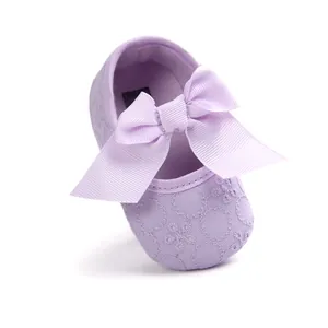Close-up of light purple baby princess shoe with embroidered floral pattern and big bow