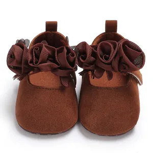 Vorderansicht brauner Baby-Mädchen-Prinzessin-Schuhe mit dekorativen Stoffblumen-Details.