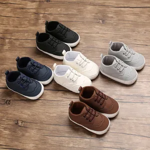 Veelkleurige collectie babyschoentjes met zachte zolen op houten ondergrond.