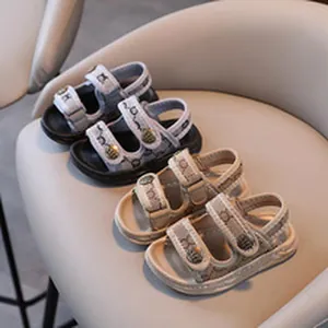 Detail view of children's monogram sandals with shell buckles and Velcro straps