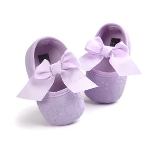 Detailed macro shot of lavender embroidered baby princess shoes with large ribbon bows