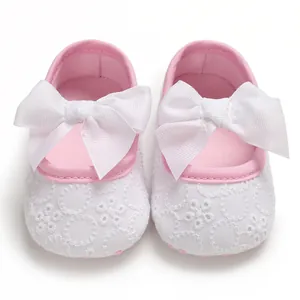 Détail de chaussures de princesse pour bébé avec dentelle blanche et un grand nœud décoratif