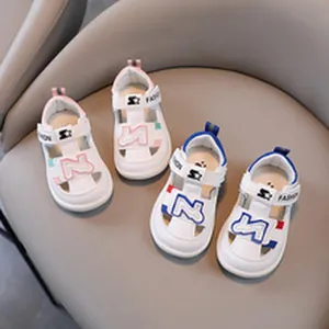 Close-up of white children's sport sandals with blue and pink accents on a chair