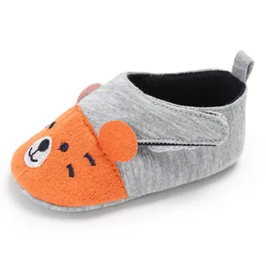 Vue détaillée de chaussures souples pour bébé avec un motif d'ours orange mignon