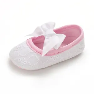 Vue détaillée de chaussures de marche princesse blanches pour bébé avec nœud blanc