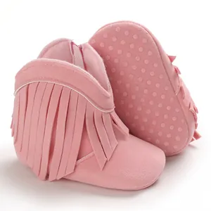 Detail view of pink baby fringe boots for infants with non-slip dotted sole design