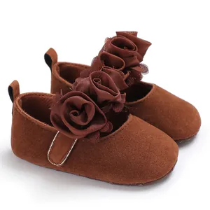 Detailansicht brauner Baby-Prinzessinenschuhe mit weicher Sohle und Stoffrosen-Deko