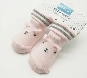 Detailed view of pink newborn baby socks featuring cute bear ears and grey striped cuffs.