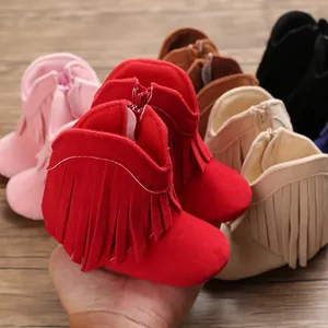 Detail of red baby tassel boots showing suede texture and convenient side zipper