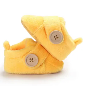 Detailed view of soft yellow fleece baby walking shoes with decorative wooden button.
