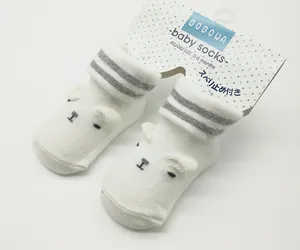 Close-up of white bear baby socks with original packaging card for 0-6 months size