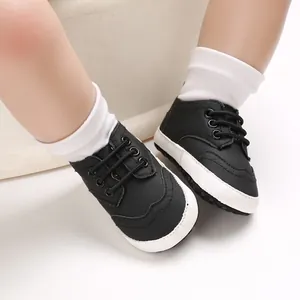 Detail van zwarte babyschoenen met zachte witte zool en sierstiksels