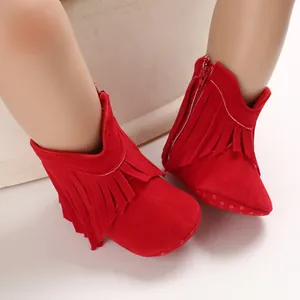 Close-up of red suede baby boots featuring stylish fringe decoration for girls