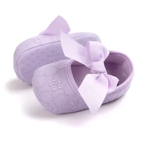 Close-up of lavender embroidered baby princess shoes with a decorative ribbon bow