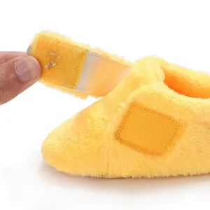 Macro view of soft yellow plush baby walker shoe featuring adjustable Velcro closure