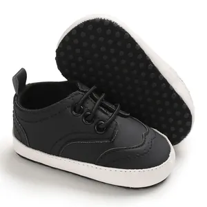 Detail van zwarte babyloopschoenen met antislip zachte zolen met stippen voor jongens.
