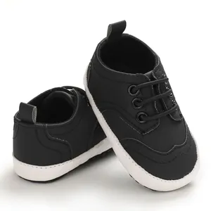 Detail van zwarte baby loopschoenen met zachte antislip witte zolen voor baby's