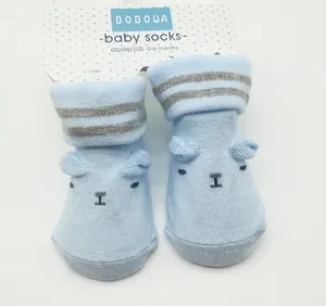 Detail showing light blue newborn baby socks with cute bear face design and 3D ears