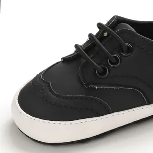 Close-up detail van zwarte baby-loopschoenen met zachte witte zolen en stevige vetersluiting