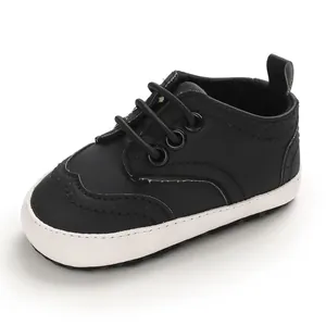Detailweergave van een zwarte baby wandelschoen met zachte witte zool en brogue naden