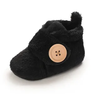 Soft black fleece baby booties with a decorative wooden button for newborn pre-walkers