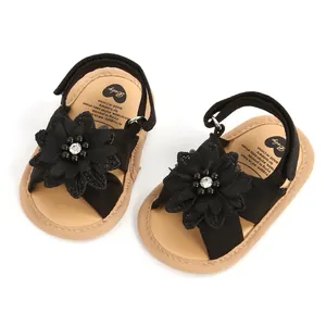 Vue détaillée de sandales noires pour bébé avec fleurs en tissu et perles élégantes