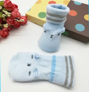 Close-up of light blue baby socks featuring a bear face design and gray stripes detail.