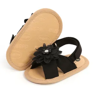Vue détaillée de sandales noires pour bébé avec semelles souples et fleurs