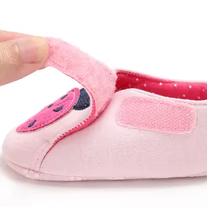 Détail de chaussure de marche rose pour bébé avec motif fraise et fermeture velcro
