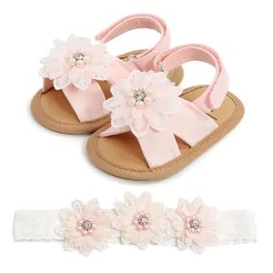 Vue détaillée de sandales roses pour bébé à semelle souple avec fleurs et bandeau