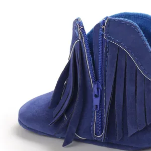 Close-up of blue suede baby boot featuring tassel fringe and side zipper detail.