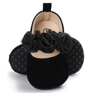Nahaufnahme schwarze Baby-Prinzessinenschuhe mit zarten Netzblumen und weicher Sohle.
